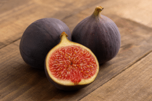 Fresh figs sliced open on a white plate with mint leaves, showcasing their fiber-rich pink interior.