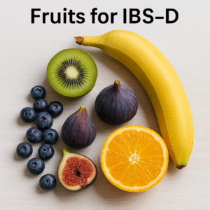 A variety of IBS-D-friendly fruits including banana, kiwi, blueberries, figs, and orange on a light wooden surface