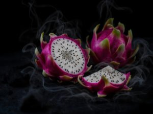 Fresh dragon fruit sliced open to reveal vibrant pink flesh with black seeds, emphasizing digestive health benefits.