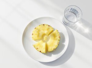 Fresh pineapple slices on a white plate for IBS-friendly digestion.